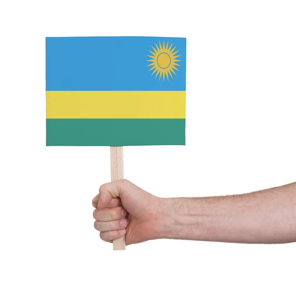 Hand som håller litet kort - flagga i Rwanda — Stockfoto