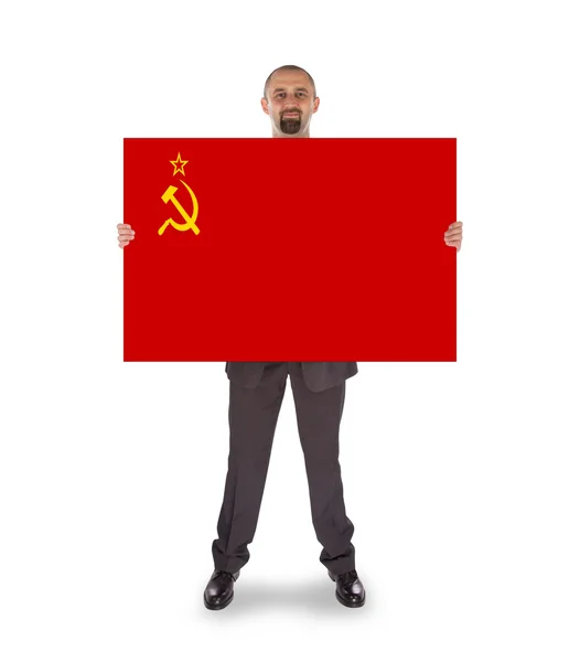 Smiling businessman holding a big card, flag of the USSR — Stock Photo, Image