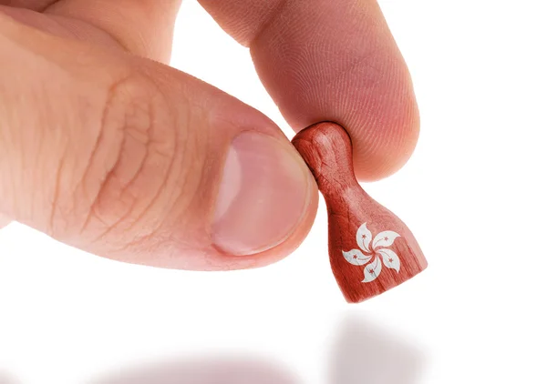 Hand holding wooden pawn, flag painting, selective focus — Stock Photo, Image