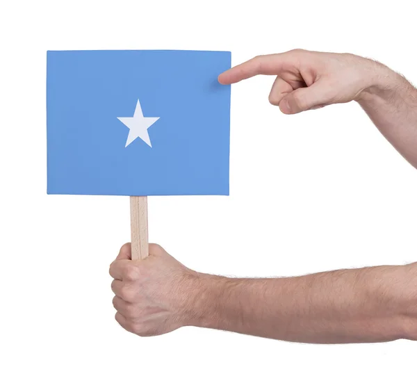 Mão segurando cartão pequeno - Bandeira da Somália — Fotografia de Stock