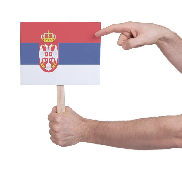 Mano sosteniendo una tarjeta pequeña - Bandera de Serbia — Foto de Stock