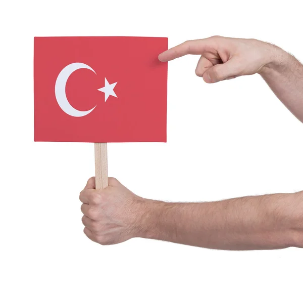 Mano sosteniendo una tarjeta pequeña - Bandera de Turquía —  Fotos de Stock
