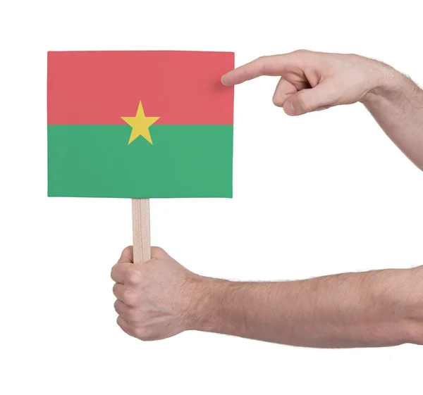 Mão segurando cartão pequeno - Bandeira de Burkina Faso — Fotografia de Stock