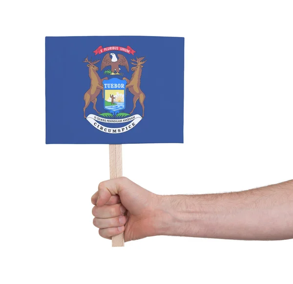 Hand som håller litet kort - flagga i Michigan — Stockfoto