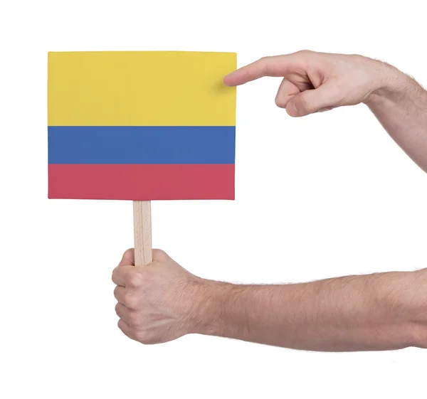 Mano sosteniendo tarjeta pequeña - Bandera de Colombia — Foto de Stock