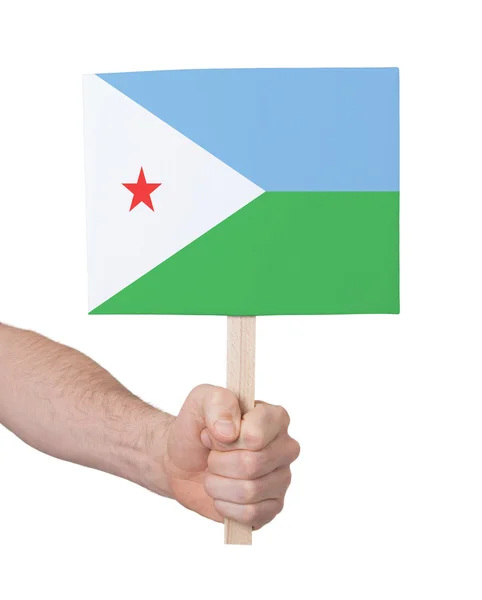 Mão segurando cartão pequeno - Bandeira de Djibouti — Fotografia de Stock