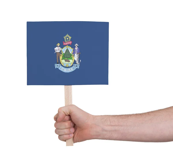 Mano sosteniendo una tarjeta pequeña - Bandera de Maine —  Fotos de Stock