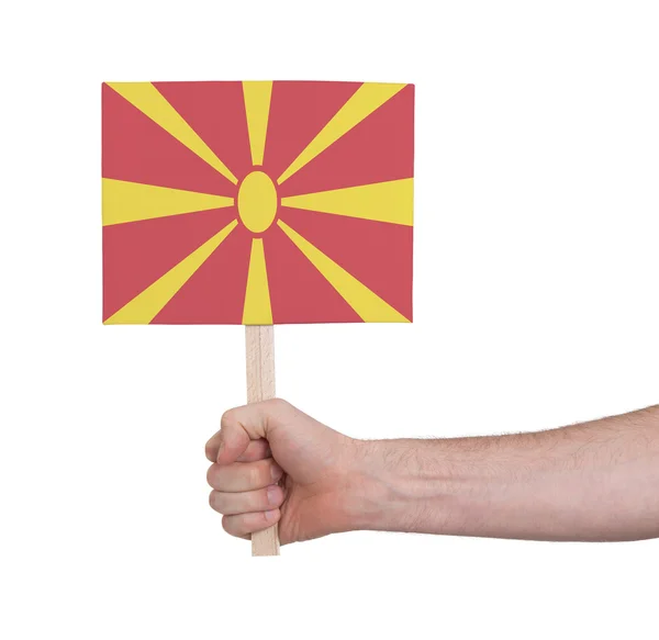 Mano sosteniendo una tarjeta pequeña - Bandera de Macedonia —  Fotos de Stock