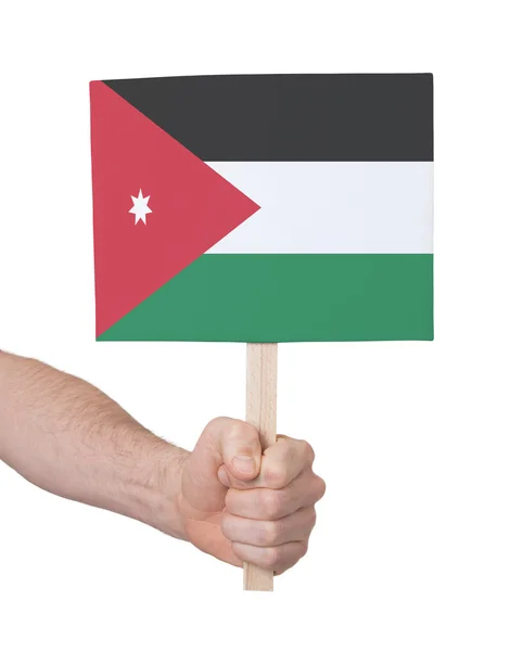 Mão segurando cartão pequeno - Bandeira da Jordânia — Fotografia de Stock