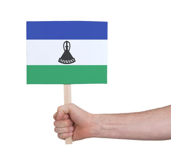 Hand met kleine kaartje - vlag van Lesotho — Stockfoto