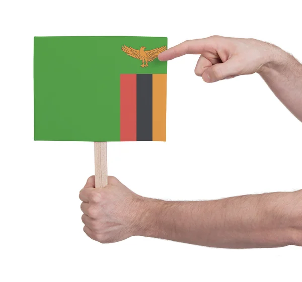 Hand hält kleine Karte - Flagge von Sambia — Stockfoto