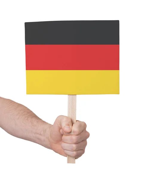 Mano que sostiene la tarjeta pequeña - Bandera de Alemania —  Fotos de Stock