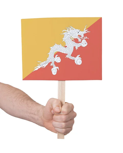 Mão segurando cartão pequeno - Bandeira do Butão — Fotografia de Stock