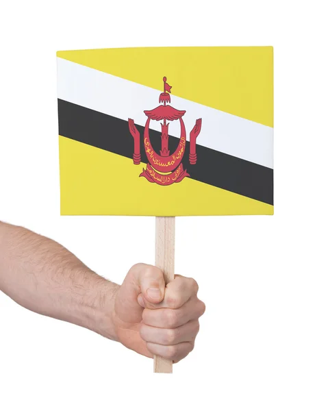 Hand met kleine kaartje - vlag van Brunei — Stockfoto