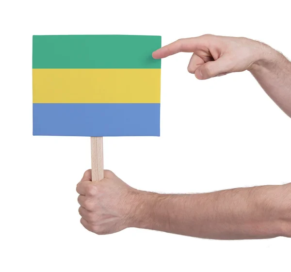 Mano sosteniendo una tarjeta pequeña - Bandera de Gabón —  Fotos de Stock