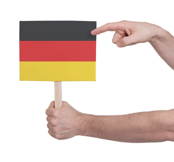 Mão segurando cartão pequeno - Bandeira da Alemanha — Fotografia de Stock