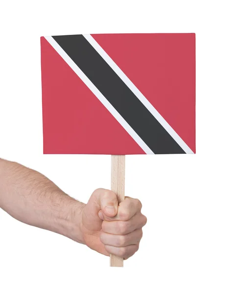 Mão segurando cartão pequeno - Bandeira de Trinidad e Tobago — Fotografia de Stock
