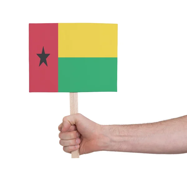 Hand met kleine kaartje - vlag van Guinee-Bissau — Stockfoto