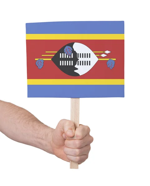 Hand som håller litet kort - flagga i Swaziland — Stockfoto