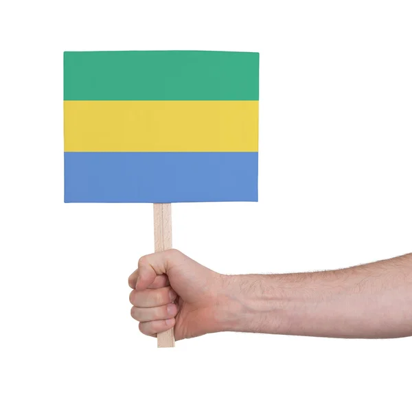 Hand hält kleine Karte - Fahne von Gabon — Stockfoto