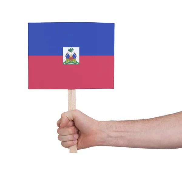 Hand met kleine kaartje - vlag van Haïti — Stockfoto