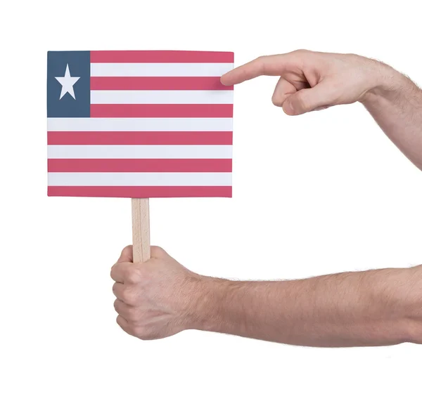 Hand hält kleine Karte - Flagge von Liberia — Stockfoto