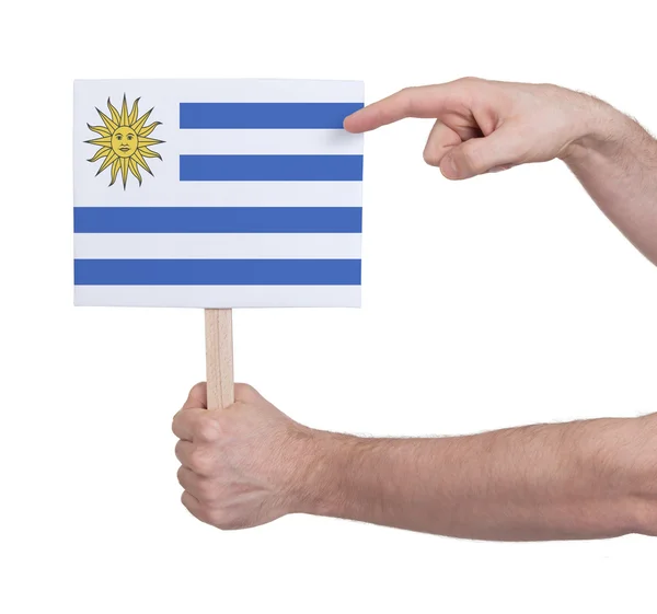 Hand met kleine kaartje - vlag van Uruguay — Stockfoto