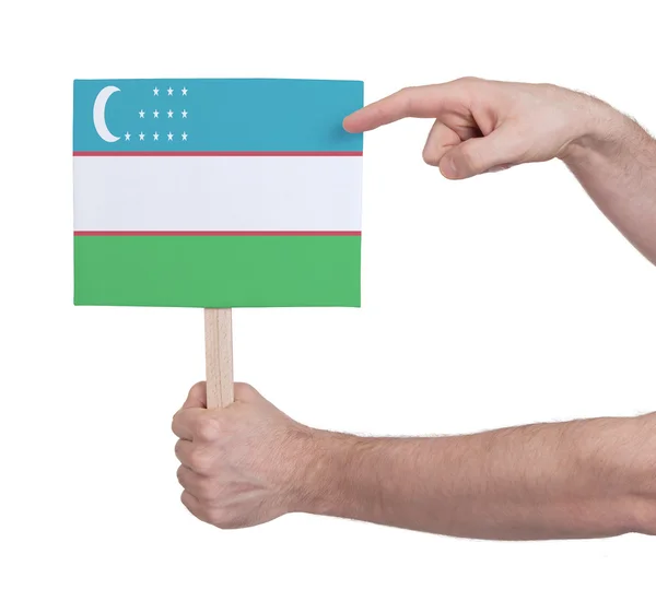 Hand hält kleine Karte - Flagge Usbekistans — Stockfoto