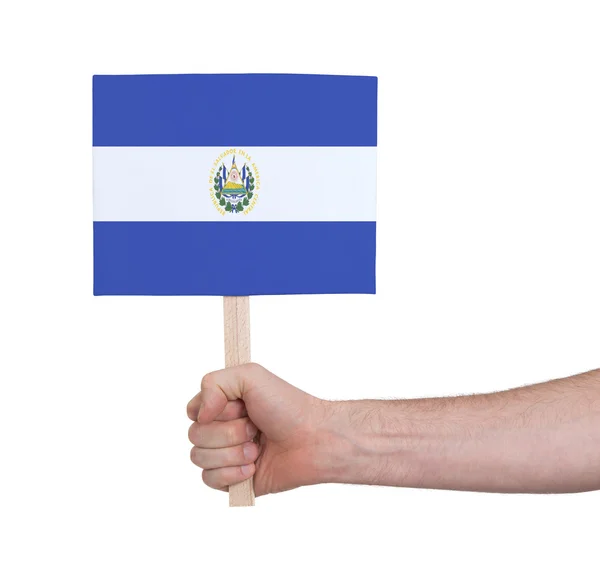 Hand som håller litet kort - flagga i El Salvador — Stockfoto