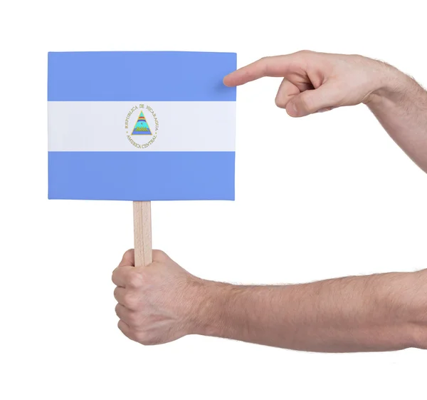 Χέρι που κρατά μικρή κάρτα - σημαία της Νικαράγουας — Φωτογραφία Αρχείου