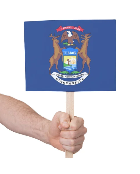 Hand som håller litet kort - flagga i Michigan — Stockfoto