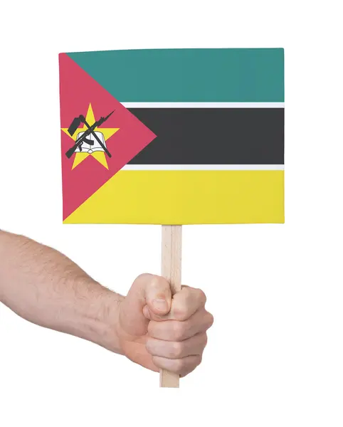 Mano sosteniendo una tarjeta pequeña - Bandera de Mozambique —  Fotos de Stock