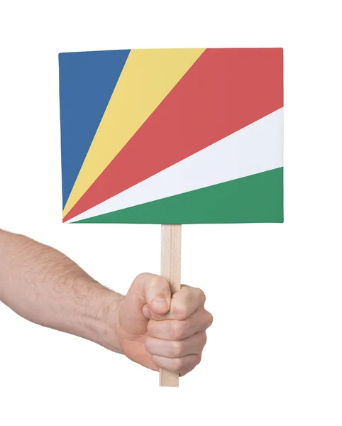 Hand hält kleine Karte - Flagge der Seychellen — Stockfoto