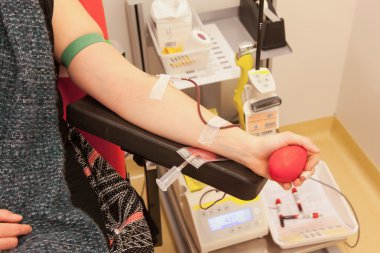Donor in an armchair donates blood clipart
