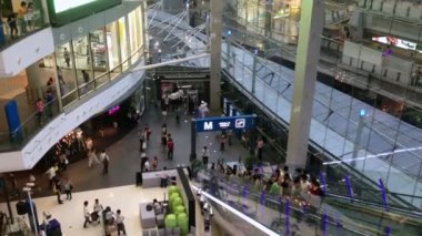 İnsanlar alışveriş merkezinde yürüyen merdiven alıyor