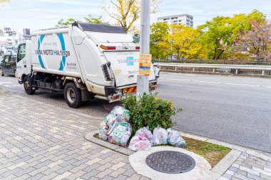 Kyoto kenti, Japonya-Aralık 04-24: Yaya yolunda çöp torbaları bulunan bir çöp kamyonunun görüntüsü, atık yönetiminin uygun atık yönetimi açısından önemini vurguluyor.