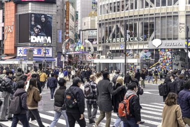Tokyo şehri, Japonya-13 Aralık 2024: Shibuya 'nın karşıdan karşıya geçen insan ve turist kalabalığının şehir manzarası. Shibuya bölgesi Tokyo 'nun simgesel bir sembolü ve metropolün çabukluğu..