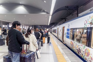 Osaka şehri, Japonya - 02 Aralık 2024: Haruka sınırlı ekspres trenini bekleyen insan ve turistlerin perspektif görüntüsü, Hello Kitty temalı Hello Kitty temalı Kyoto ile Kansai Havaalanı ve Kyoto arasında çalışır..