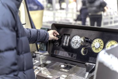 İnsanların eli, tren müzesinin tren sürücüsü bölgesinde trenin sürüş sistemini kontrol eden kollara dokunmaya ve kontrol etmeye çalışıyor..