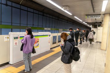 Tokyo Şehri, Japonya-11 Aralık 2024: Metroda bekleyen insanların yakın çekim ve perspektifi.