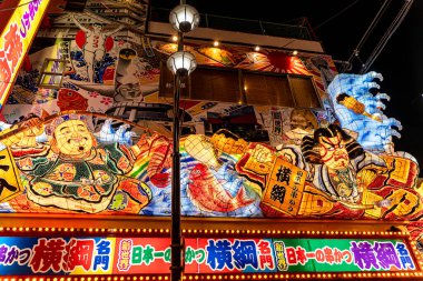 Osaka şehri, Japonya - 07 Aralık 2024: Gece vakti Shinsekai bölgesinde Japon restoranının ilginç tabelasının kapatılması. Shinsekai bölgesi Osaka 'da popüler bir turizm merkezidir.