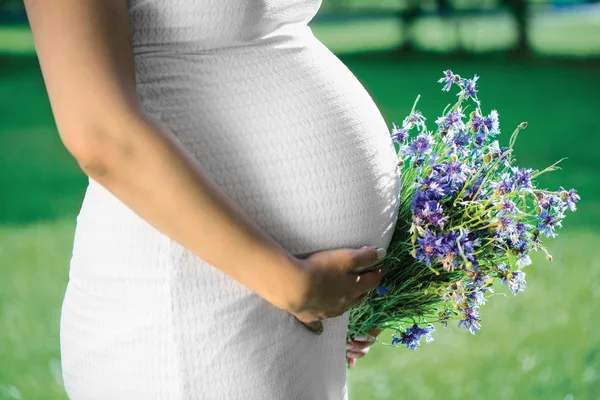 Pregnant woman with flowers — Stock Photo, Image