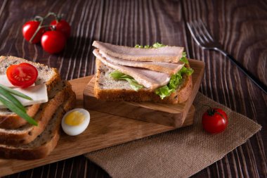 Taze sebzeli konserve ton balığı dilimleri ve mutfak tahtasının üzerinde ekmek ahşap arka planda sağlıklı yiyecekler.