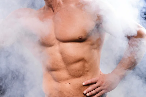 Muskulös bodybuilder över rök — Stockfoto