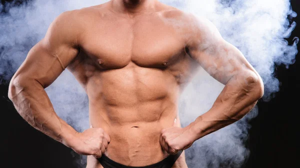 Musculoso culturista sobre humo —  Fotos de Stock