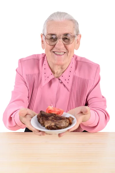 Old woman holding meat — Stock Photo, Image