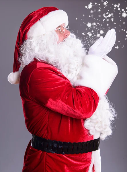 Weihnachtsmann bläst Schneeflocken ab — Stockfoto