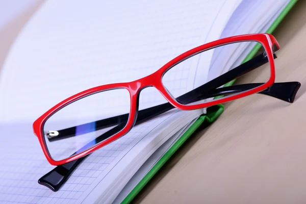 Anteojos y cuaderno de papel — Foto de Stock