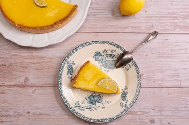 Tahta bir masada eski bir tabakta limonlu turta dilimi