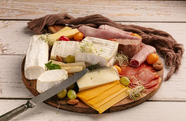 Käse Und Wurstsortiment Auf Einem Holztablett Auf Einem Tisch — Stockfoto